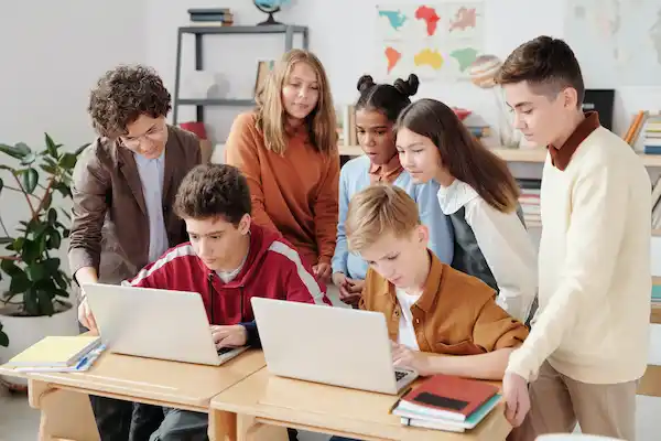Adolescentes em sala de aula numa mesa com livros ilustrando o curso de ingles para adolescentes da fourflags