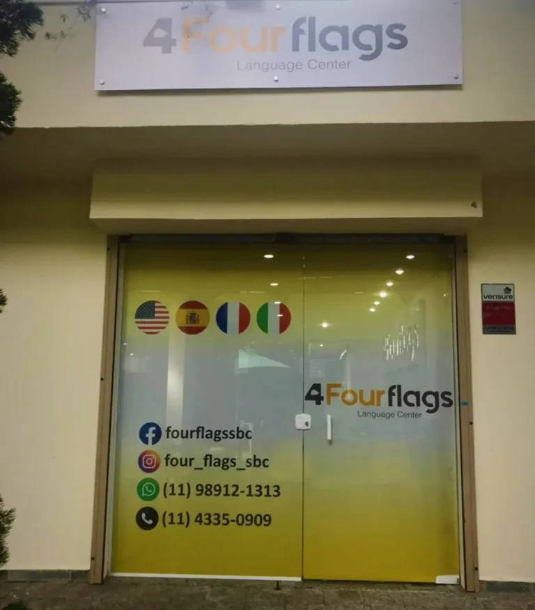 Fachada da escola de idiomas FourFlags em São Bernardo do Campo, com informações de contato e bandeiras dos cursos de inglês, espanhol, francês e italiano visíveis na vitrine.