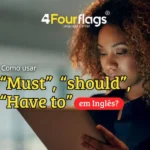 Dica de inglês da escola de idiomas FourFlags em São Caetano do Sul explicando como usar must, should e have to em inglês, com a imagem de uma mulher concentrada usando um tablet.