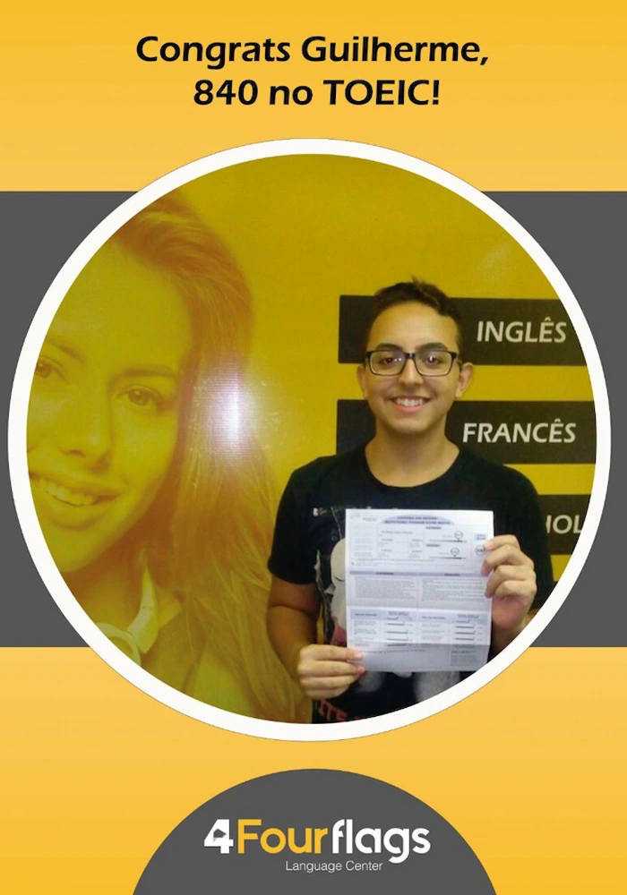 Aluno Guilherme sorrindo e segurando seu certificado com a pontuação de 840 pontos no exame TOEIC, comprovando a garantia de aprendizado da escola de idiomas FourFlags em São Caetano do Sul.