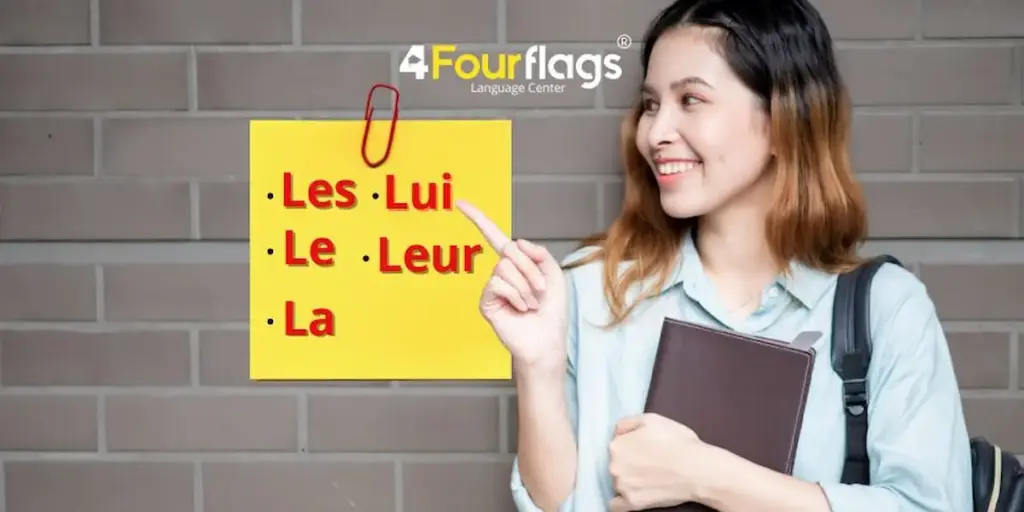 Pronomes de objeto direto e indireto em francês: imagem ilustrativa com jovem estudante apontando para um bloco de notas amarelo com os pronomes les, le, la, lui e leur, oferecido pela FourFlags Language Center